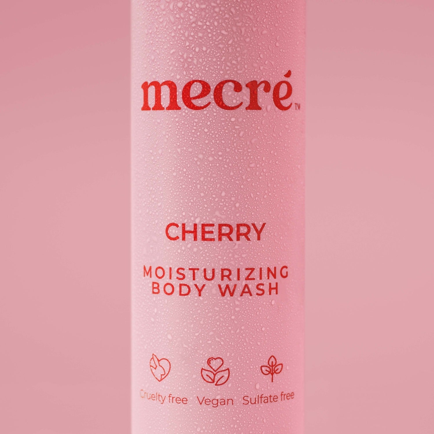 Close-up of water droplets on a Mecré moisturizing body wash cherry-scented bottle.