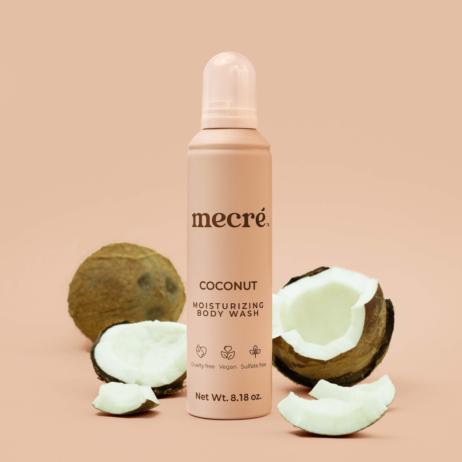 Mecré moisturizing body wash coconut-scented bottle surrounded by coconuts.