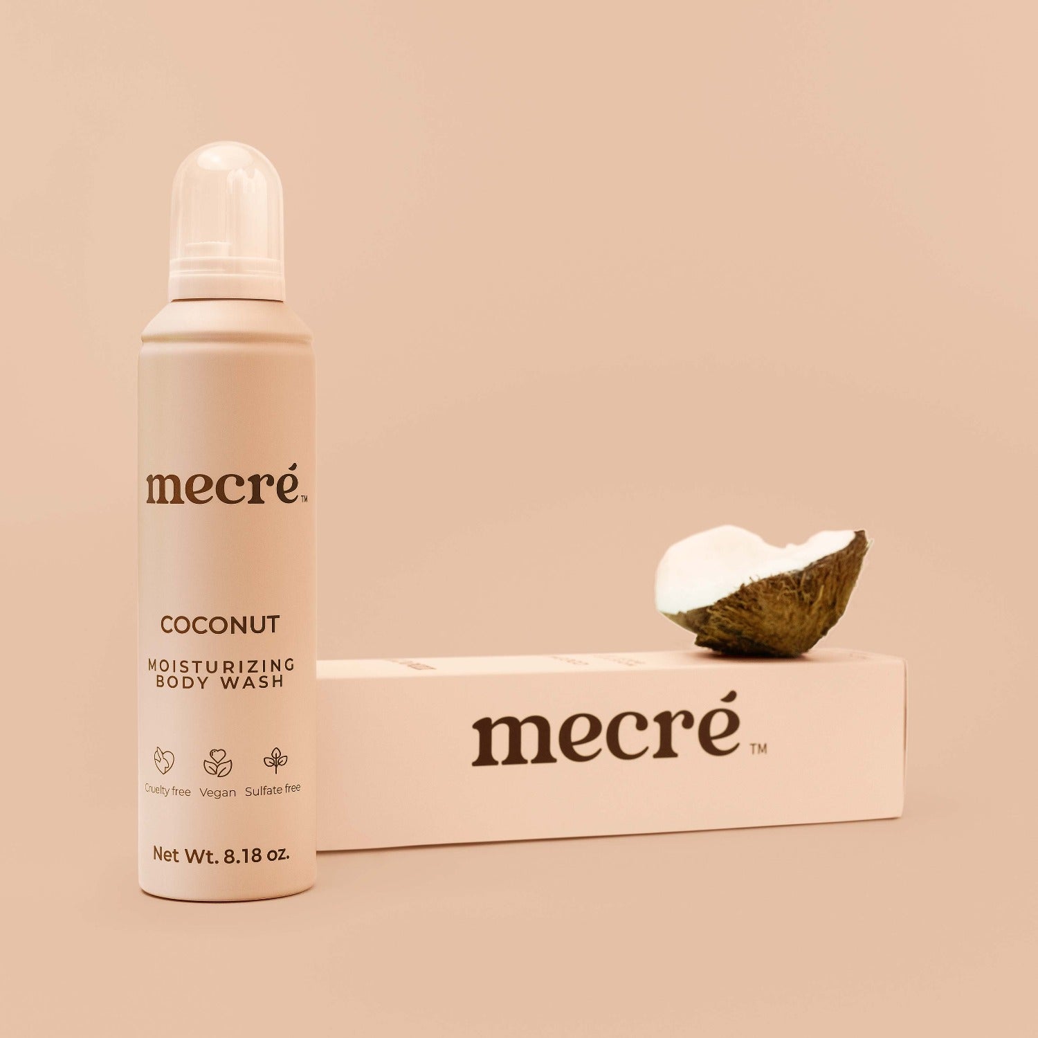 Front view of Mecré moisturizing body wash in coconut scent, displayed with its packaging and half coconut.