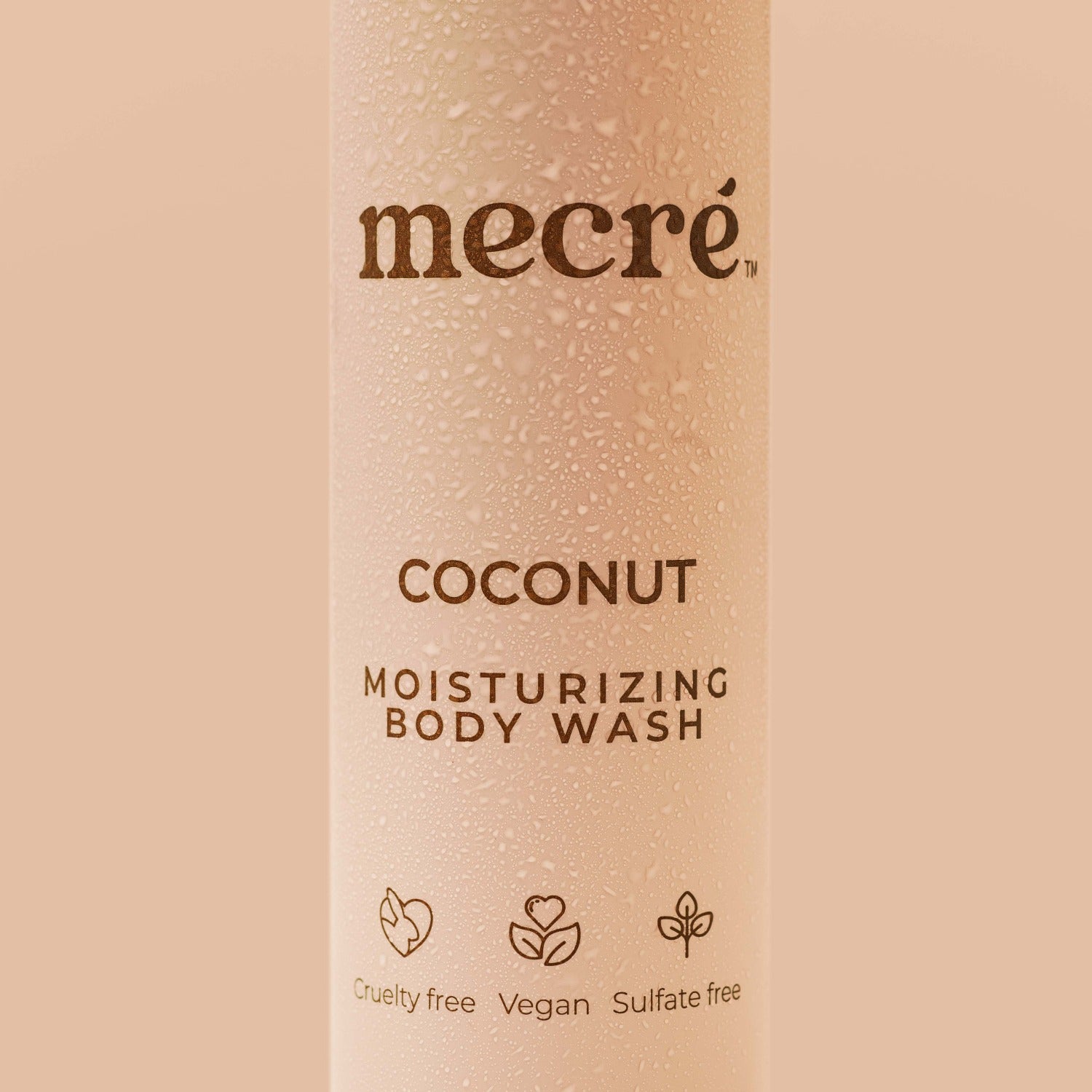 Close-up of water droplets on a Mecré moisturizing body wash coconut-scented bottle.