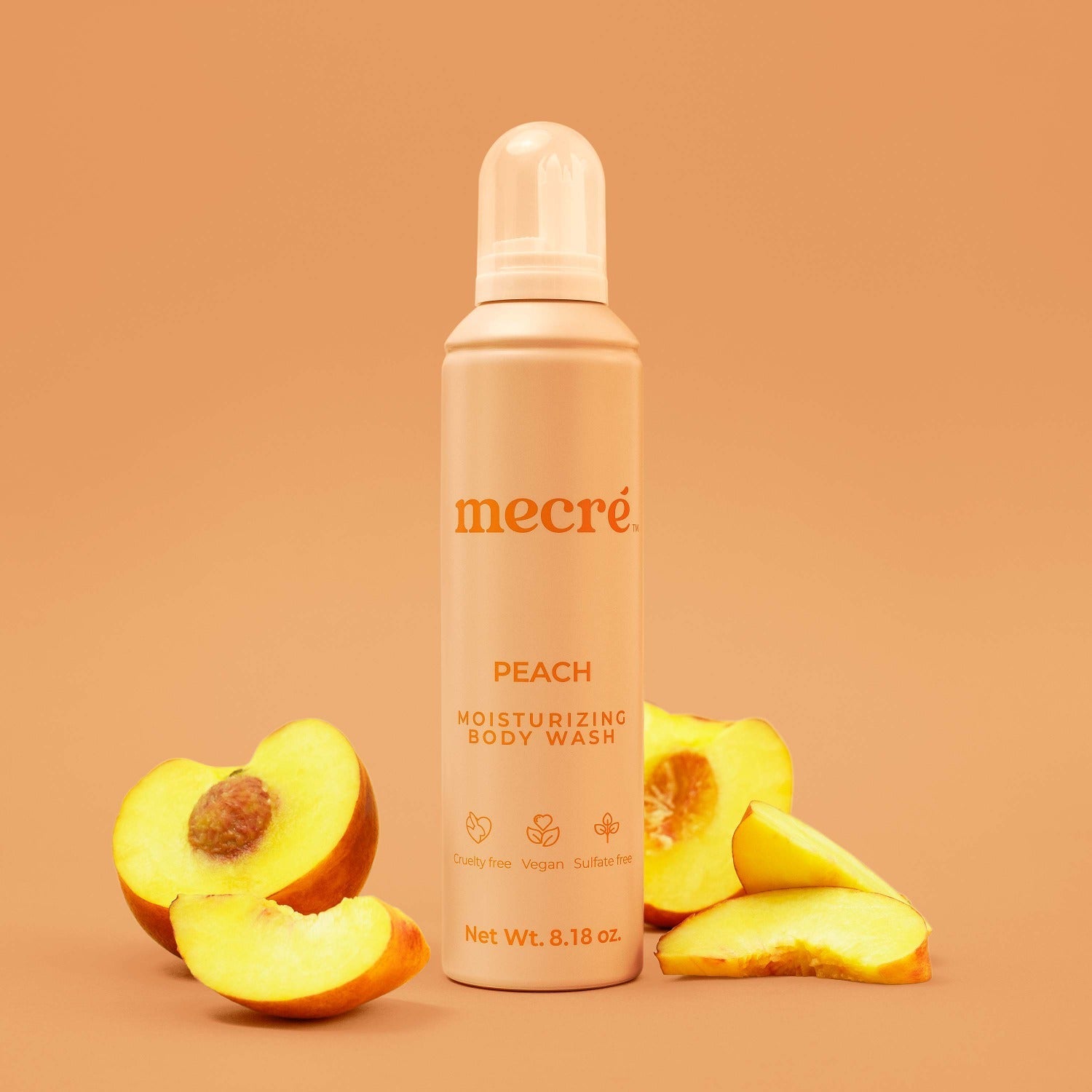 Mecré moisturizing body wash peach-scented bottle surrounded by peaches.