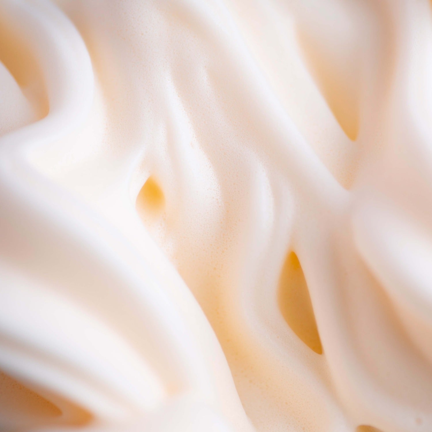 Close-up of Mecré moisturizing body wash with peach scent, presenting creamy, light orange foam.